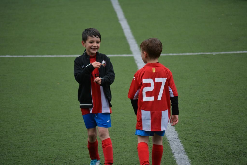 two boy standing on soccer field